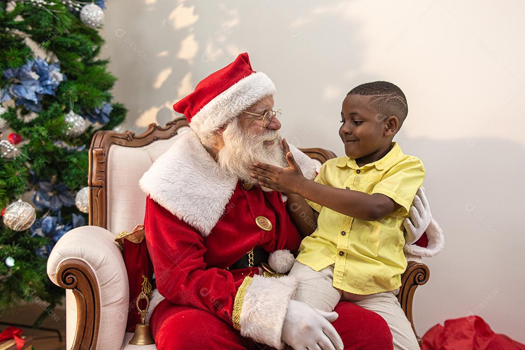 Papai Noel entregando uma caixa de presente para um menino africano