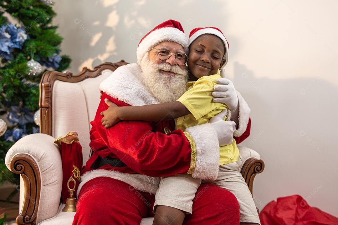Papai Noel entregando uma caixa de presente para um menino africano