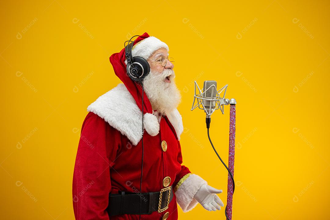 Papai Noel cantando ou falando em um microfone de estúdio.