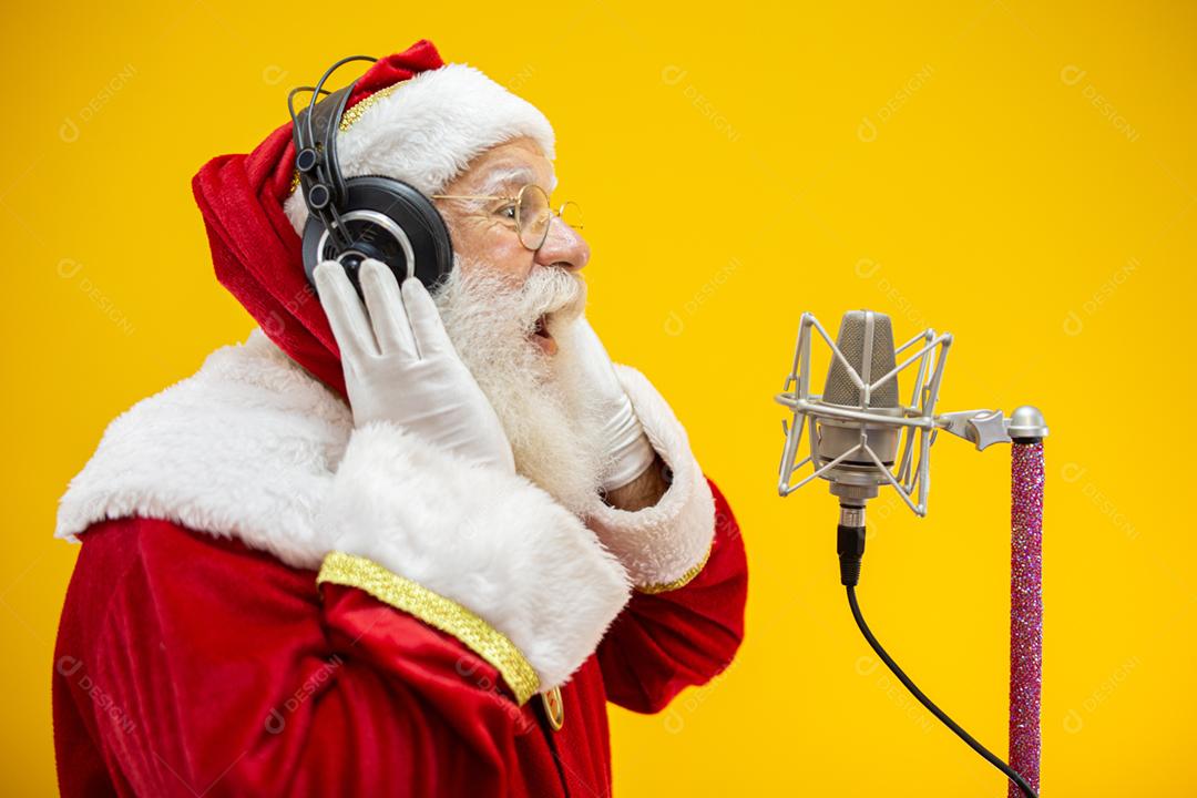 Papai Noel cantando ou falando em um microfone de estúdio. Feliz Natal. Locutor de rádio