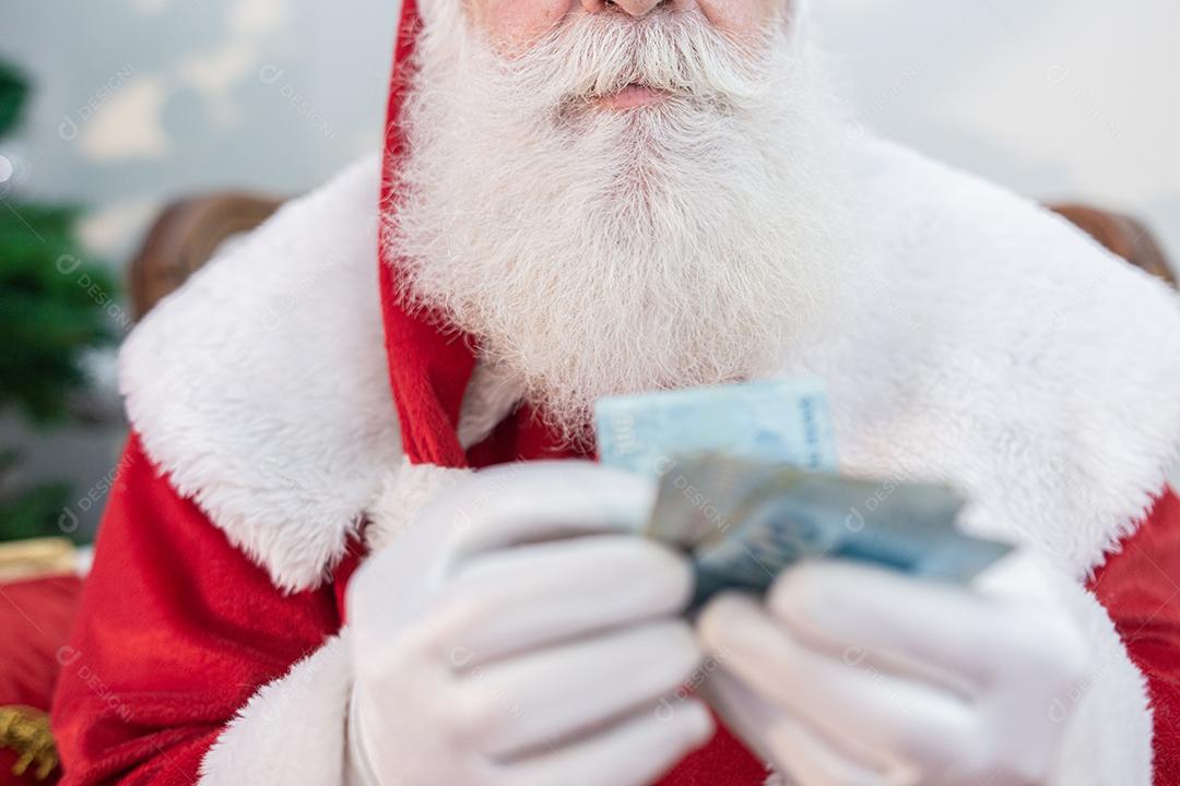 Papai Noel oferecendo um presente e dinheiro para a câmera. Recebimento