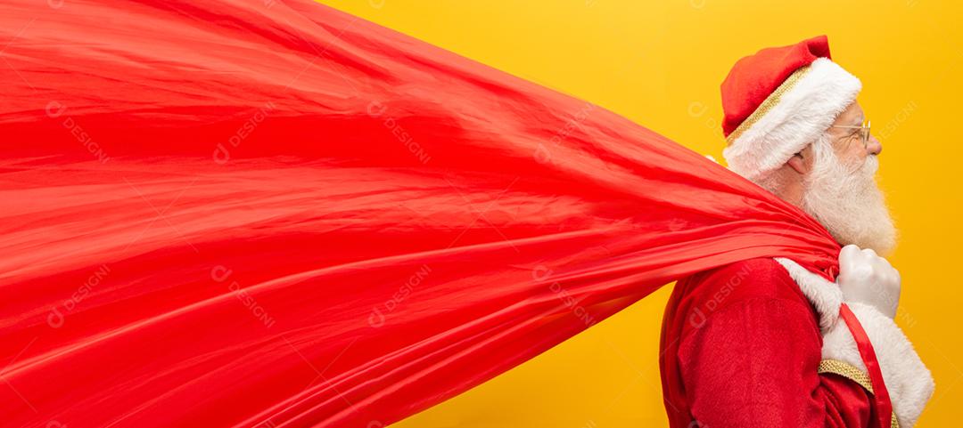 Papai Noel puxando um enorme saco de presentes em fundo amarelo  Arte da bandeira.