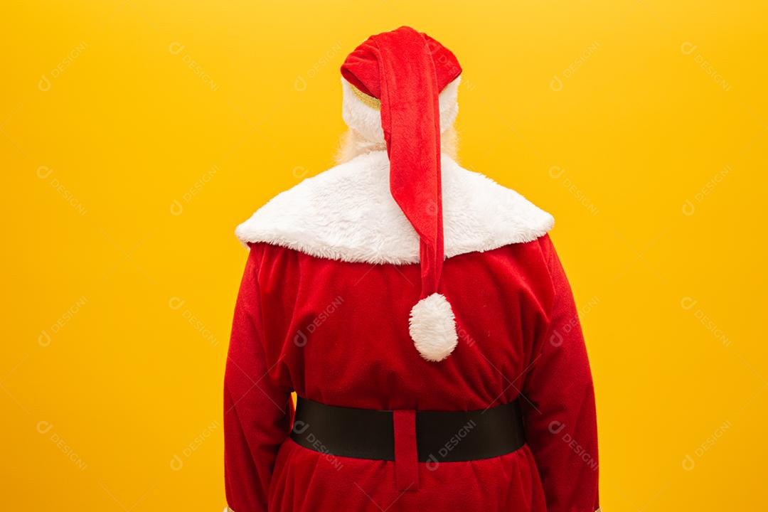Papai Noel de costas em fundo amarelo. Papai Noel por trás, olhando para trás.