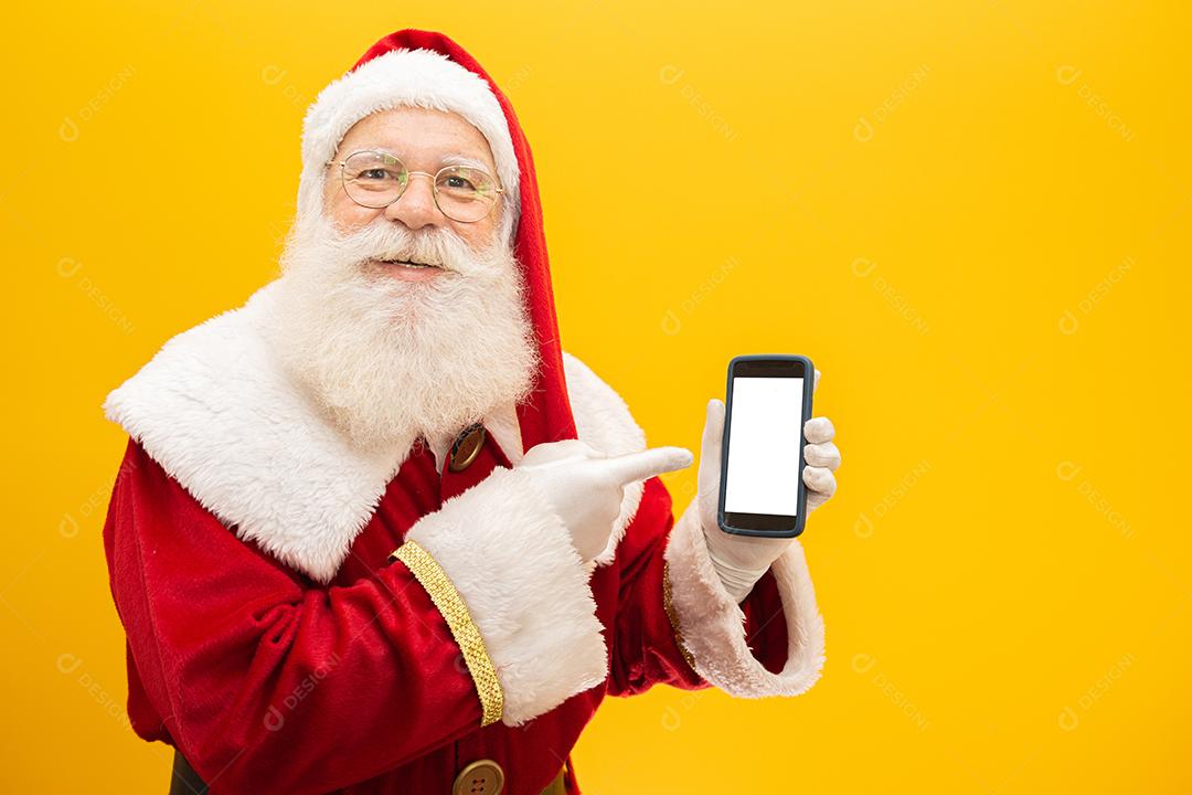 Papai Noel com celular no fundo amarelo. Conceito de comunicador