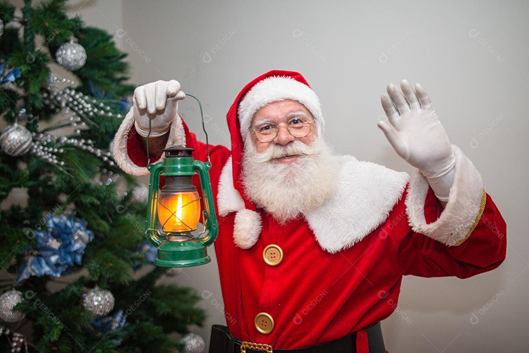 Papai Noel segurando uma lâmpada ficando em silêncio em uma casa. Natal
