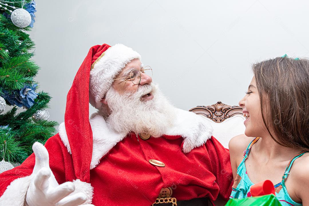 Papai Noel entregando uma caixa de presente a uma garotinha. Natal