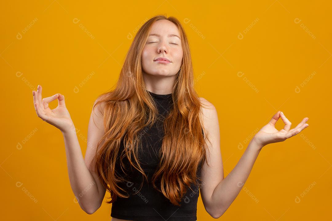 Ruiva mulher caucasiana em pé sobre fundo amarelo isolado