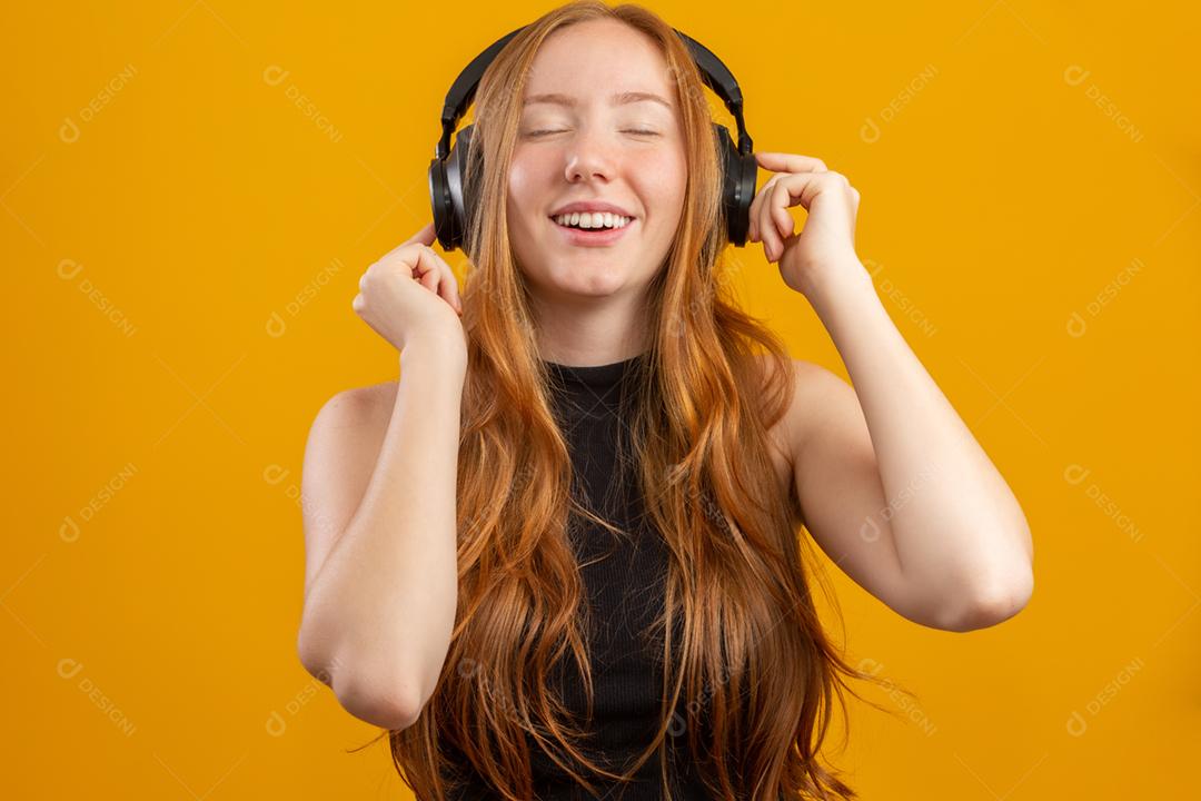 Garota hipster ruiva animada feliz e despreocupada como seus novos fones de ouvido, dançando