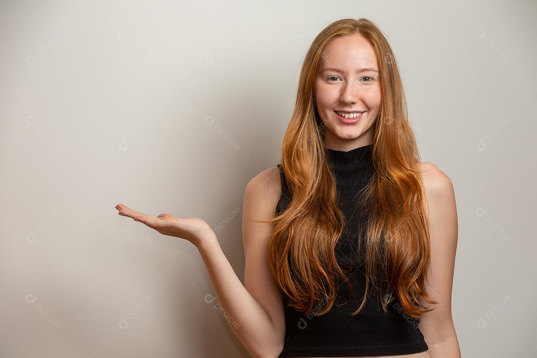 Uma garota ruiva no fundo do estúdio branco oferece oportunidades