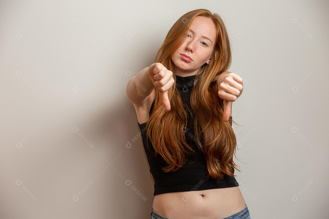 Infeliz ruiva infeliz mulher ruiva dando polegares para baixo gesto