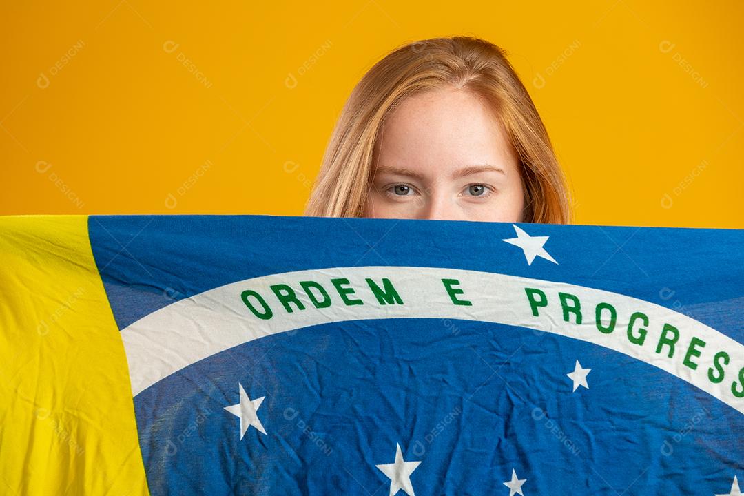 Fã misteriosa de ruiva segurando uma bandeira do Brasil