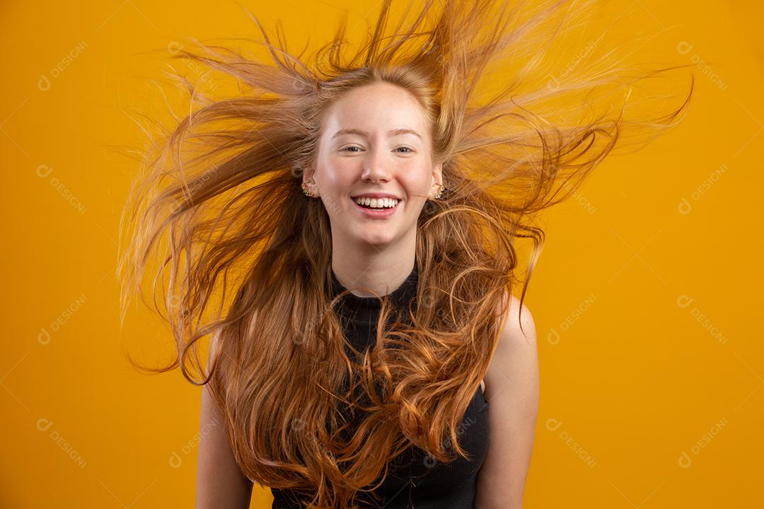 Retrato de linda menina ruiva alegre com cabelo ruivo voador