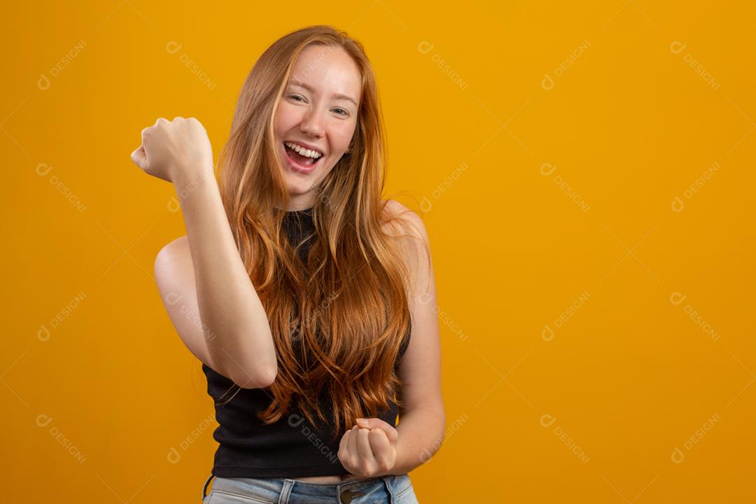 Eu tenho que vencer. Fêmea jovem ruiva alegre aperta os dentes, levanta os dedos cruzados