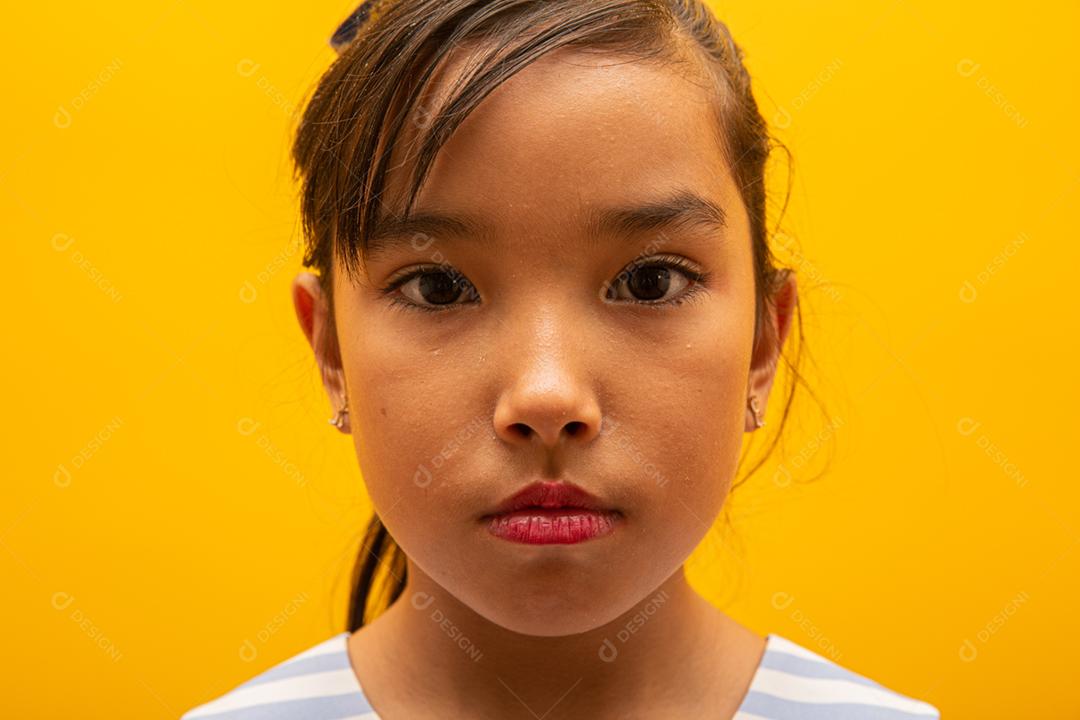 Beautiful Asian girl sitting on the yellow background. Happy Asian girl smiling.