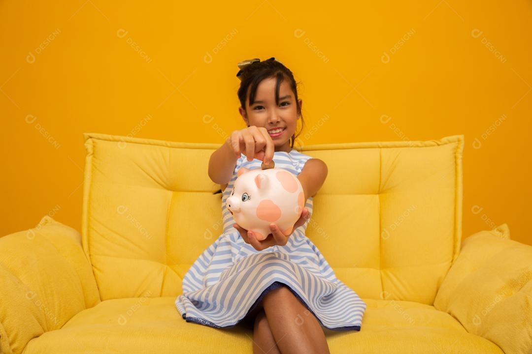 Uma menina asiática (coreana, japonesa ou chinesa), criança, estudante, criança, mulher, fêmea no sofá