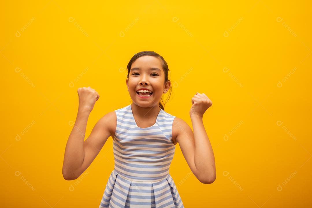 Jovem linda menina asiática alegremente regozijando-se dizendo sim. Conceito de sucesso e realização