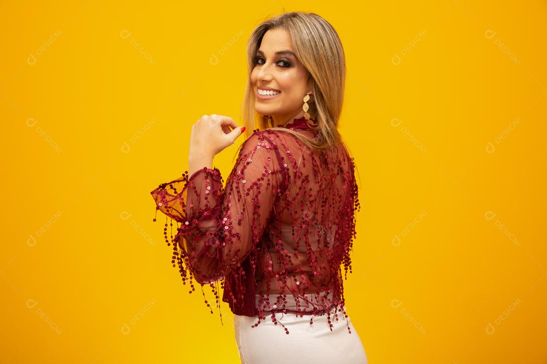 Linda mulher loira no tema da moda. Jovem mulher bonita vestindo moda t-shirt sobre fundo amarelo