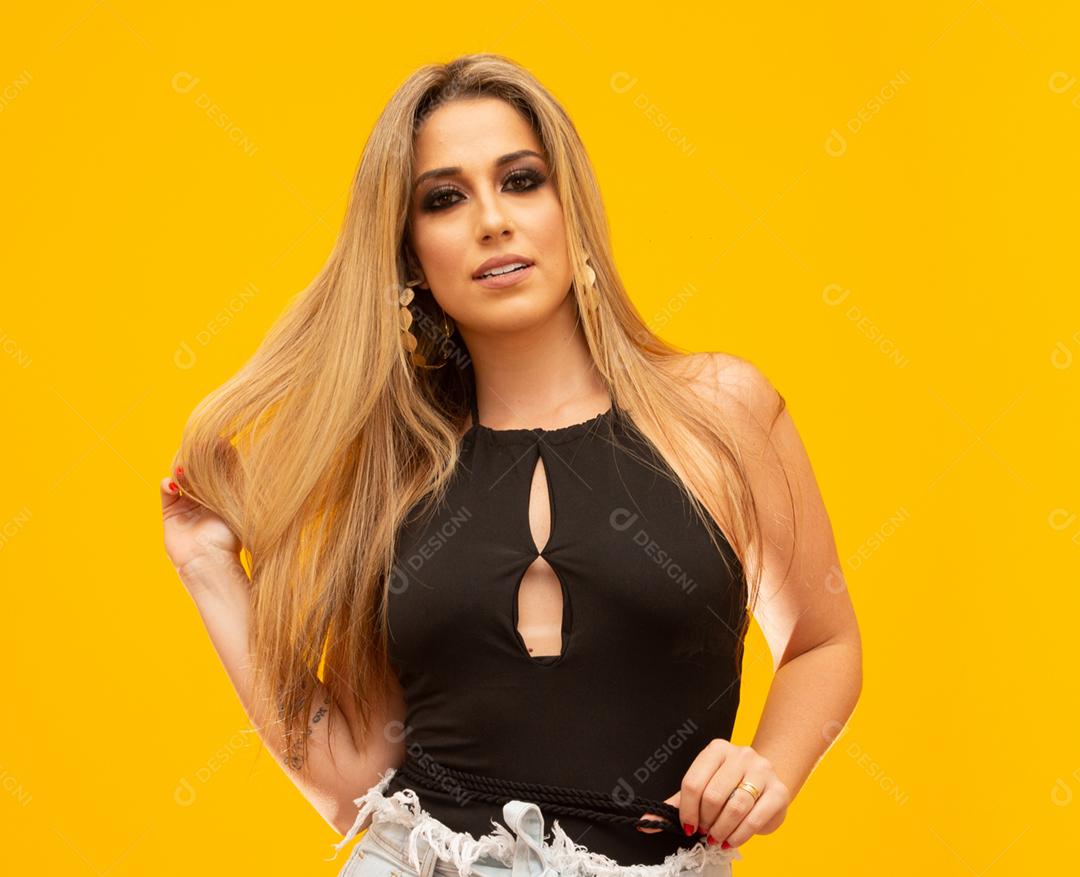 Linda mulher loira no tema da moda. Jovem mulher bonita vestindo moda t-shirt sobre fundo amarelo