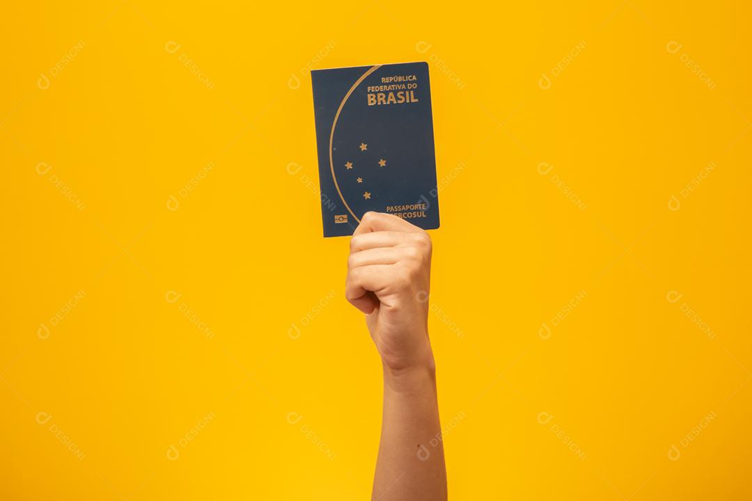 Garota segurando passaporte brasileiro.