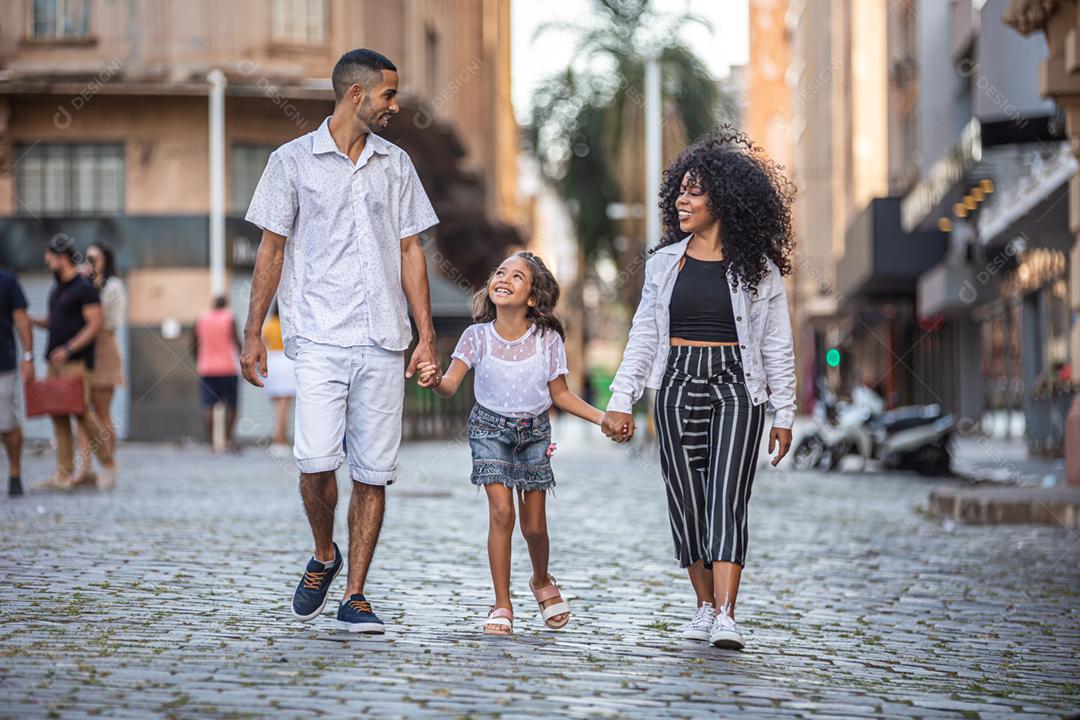 Brazilian traditional family. Father and mother walking with their daughter.