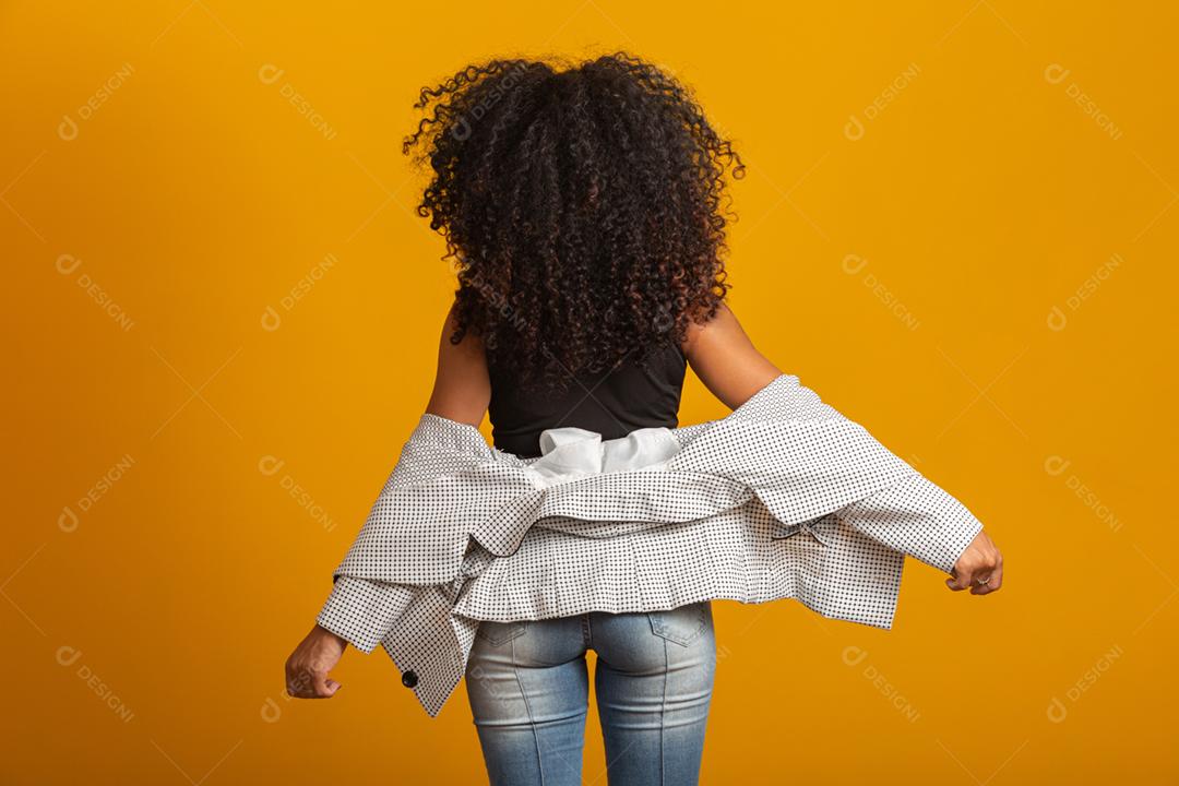 Jovem negra nas costas com penteado afro em fundo amarelo. Garota com penteado africano. Tiro de estúdio.