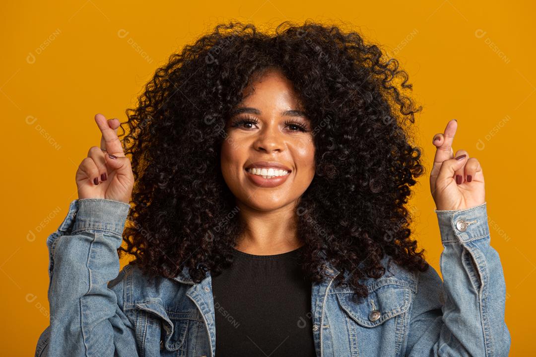 I have to win. Cheerful young brunette clenches teeth, raises crossed fingers, makes a wish