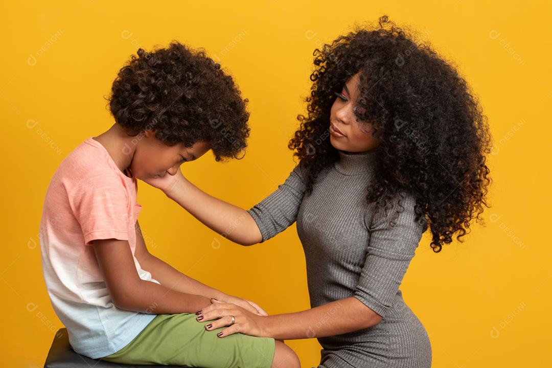 Cuidando da mãe afro-americana preocupada segurando a mão do triste filho mestiço