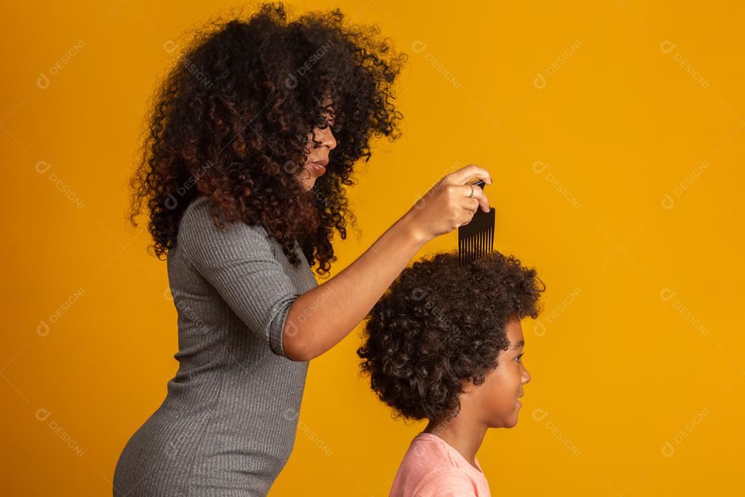 Jovens afro-americanos penteando o cabelo isolado. Garfo para pentear cabelos cacheados