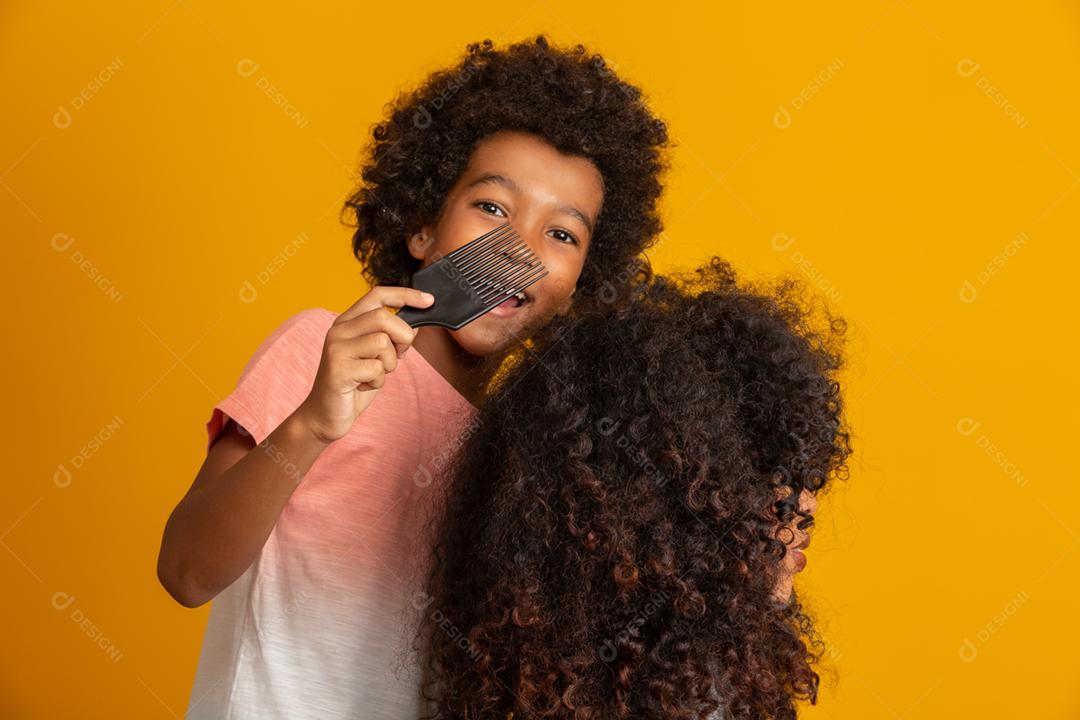 Jovens afro-americanos penteando o cabelo isolado. Garfo para pentear cabelos cacheados