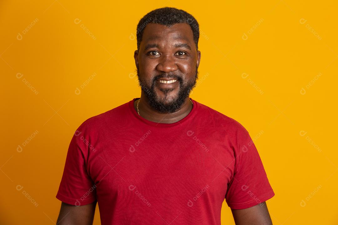 Homem afro-americano sorri com cara de feliz.