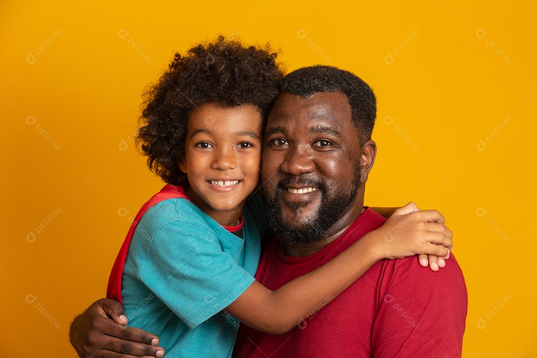 Africano pai e filho jogando super-herói na hora do dia. Pessoas se divertindo fundo amarelo