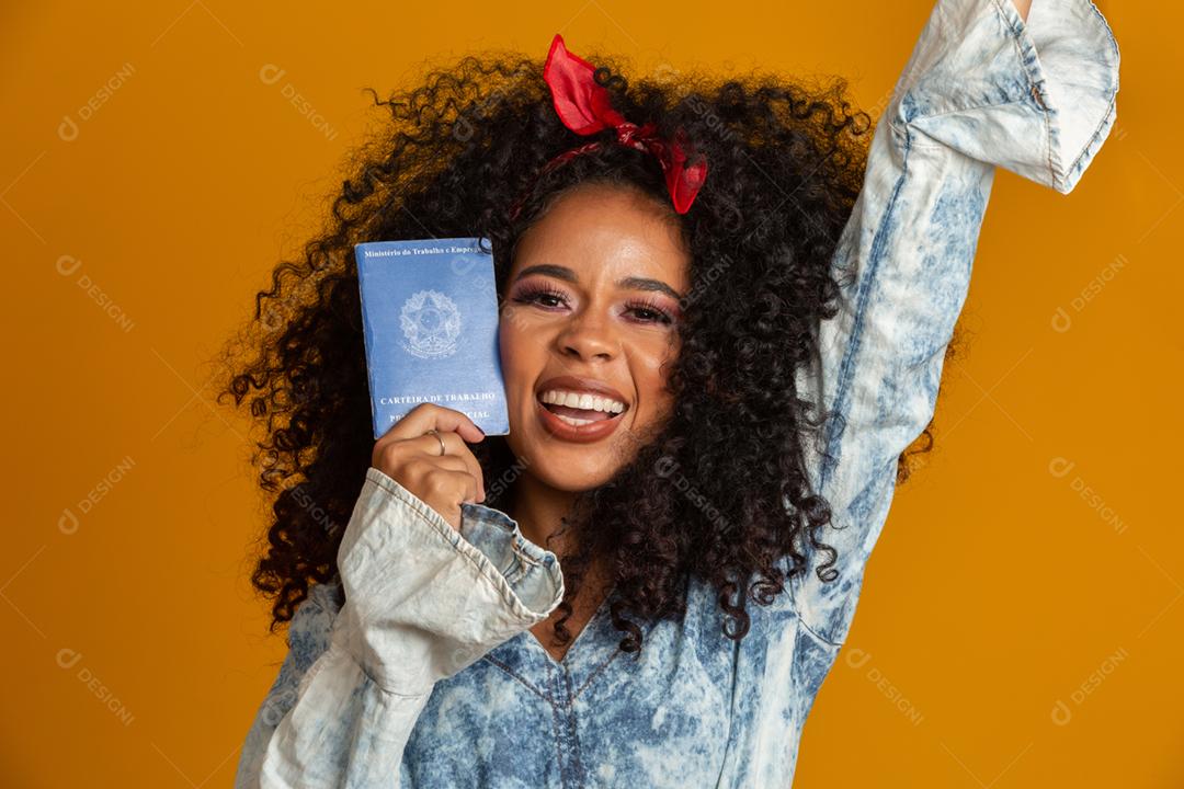 Linda garota de cabelos cacheados segurando um cartão de trabalho. Em fundo amarelo.