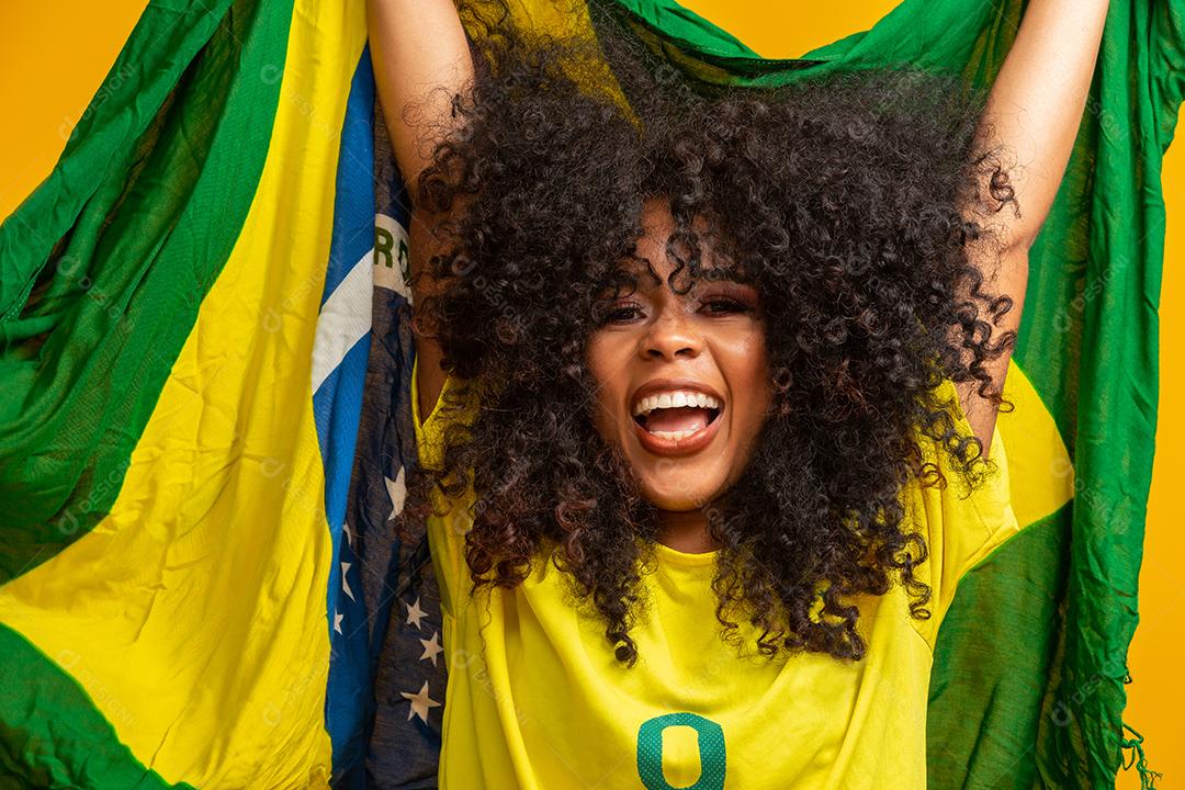 Garota afro torcendo pelo time brasileiro favorito, segurando a bandeira nacional