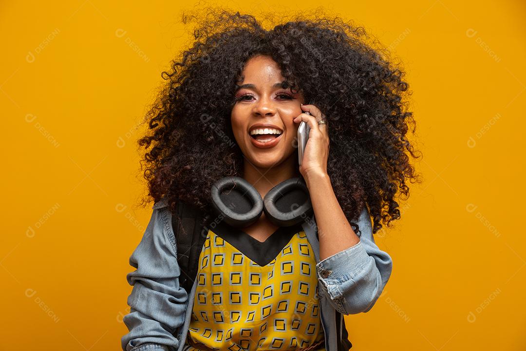 Beautiful girl talking on the phone. Communicating on the phone on a yellow background.