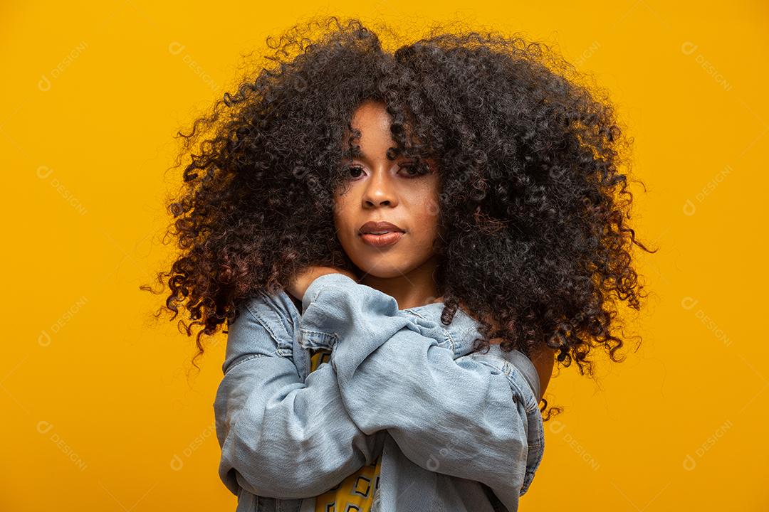 A mulher afro alegre aponta discute uma promoção incrível, cede caminho ou direção, veste