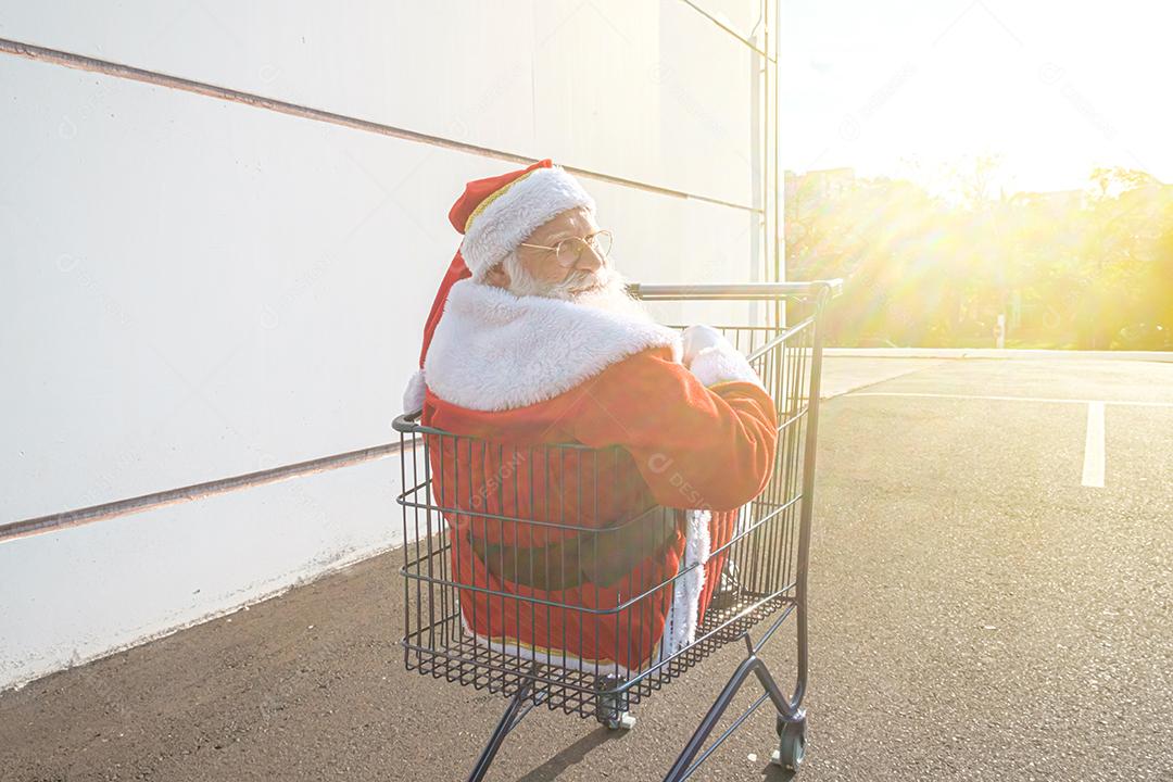 Carrinho de supermercado com Papai Noel dentro. Compras para o conceito de Natal.