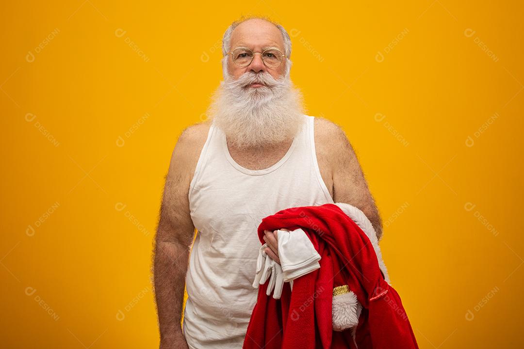 Papai Noel segurando suas roupas antes ou depois de entregar os presentes. As roupas do Papai Noel. Fantasia.