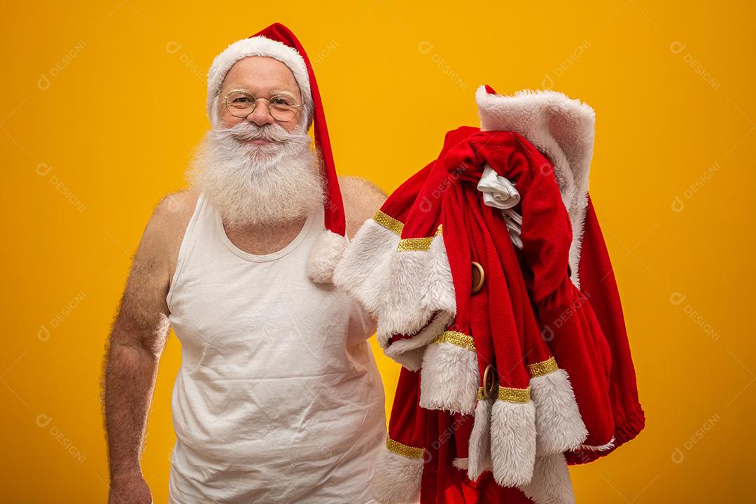 Papai Noel segurando suas roupas antes ou depois de entregar os presentes. As roupas do Papai Noel. Fantasia.