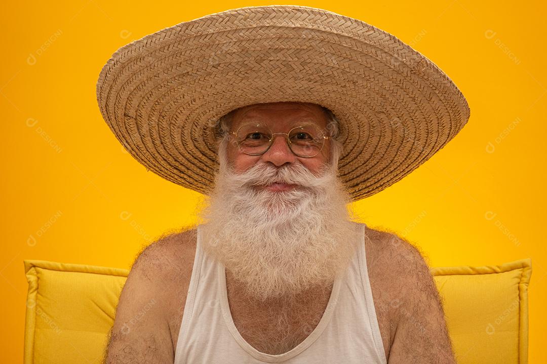 Velho com longa barba branca, usando um grande chapéu de palha.