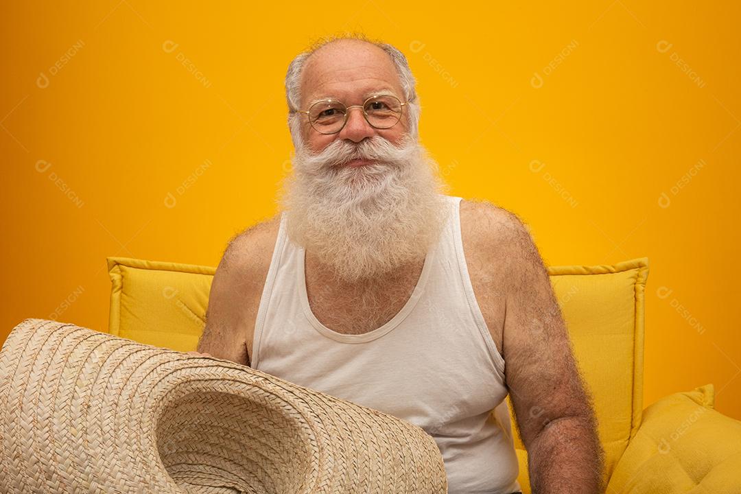 Velho com longa barba branca, usando um grande chapéu de palha.
