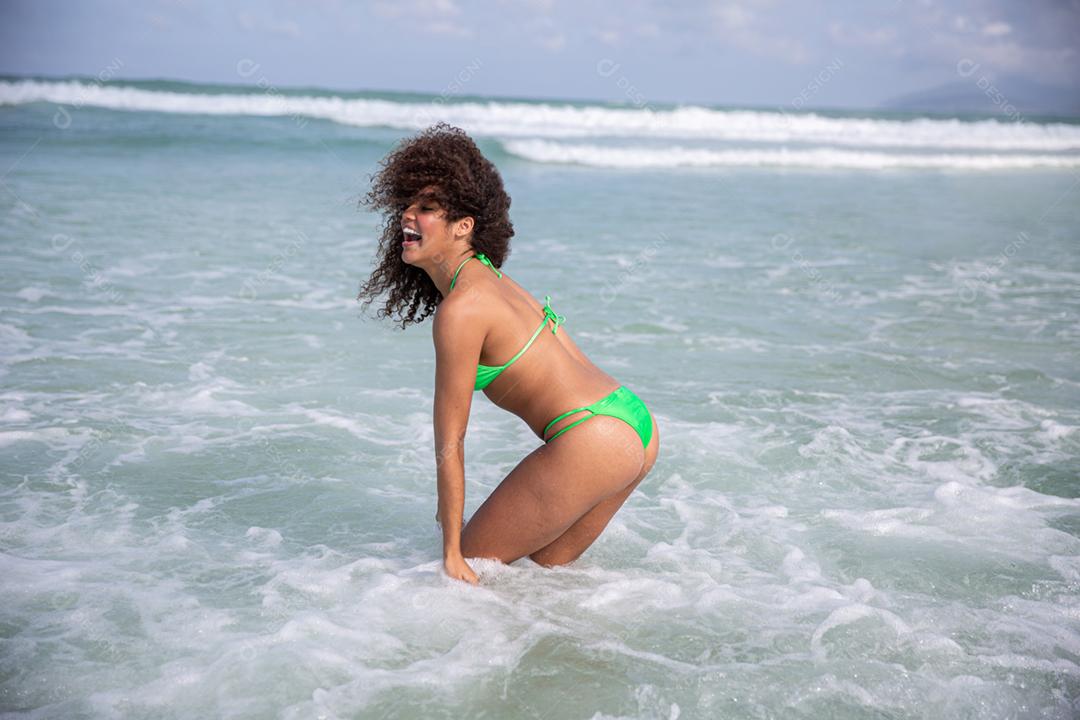 Afro morena jovem bonita, cabelo encaracolado, biquíni, praia. Férias de férias de verão