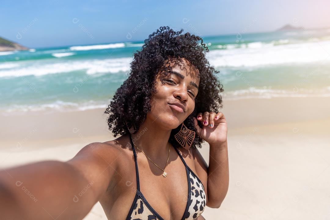 Afro morena jovem bonita, cabelo encaracolado, biquíni, praia. Férias de férias de verão