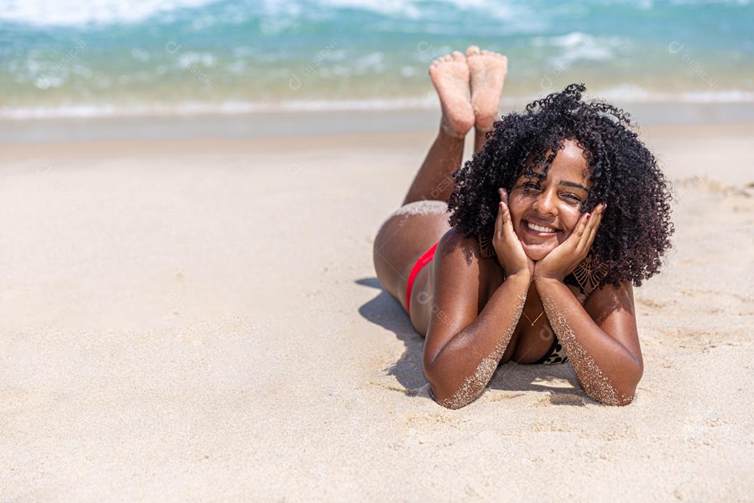 Afro morena jovem bonita, cabelo encaracolado, biquíni, praia. Férias de férias de verão
