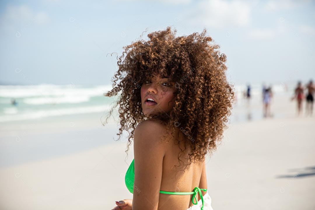 Afro morena jovem bonita, cabelo encaracolado, biquíni, praia. Férias de férias de verão