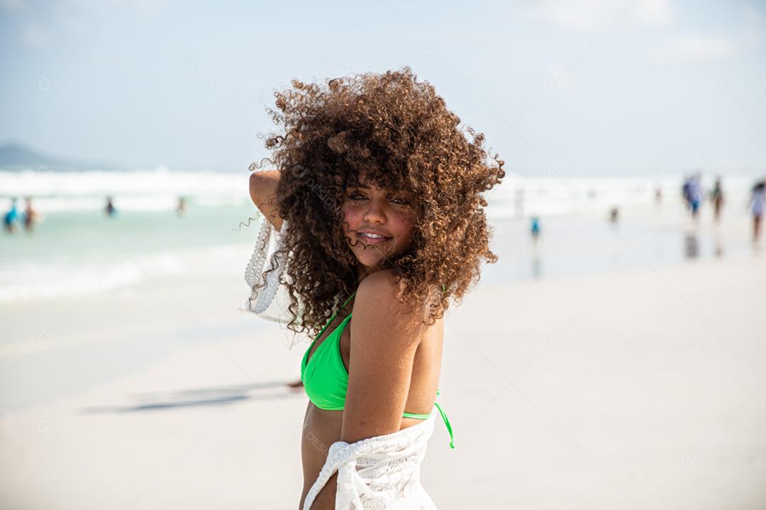 Afro morena jovem bonita, cabelo encaracolado, biquíni, praia. Férias de férias de verão