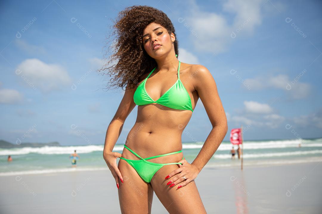Afro morena jovem bonita, cabelo encaracolado, biquíni, praia. Férias de férias de verão