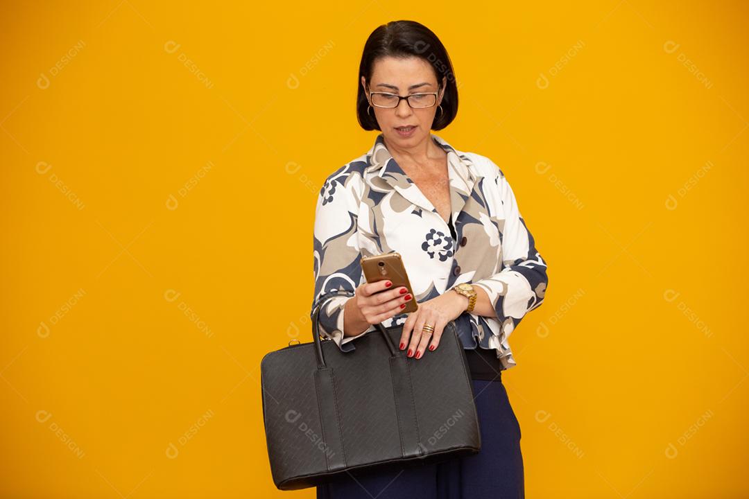 Foto de uma empresária madura atraente trabalhando com seu telefone celular