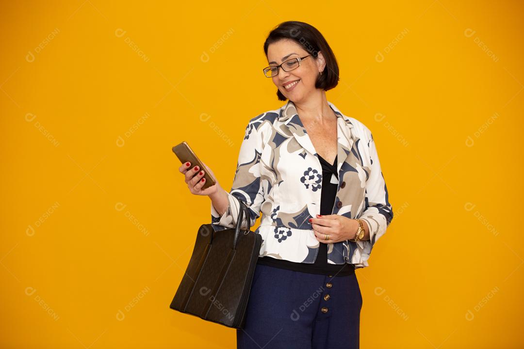 Foto de uma empresária madura atraente trabalhando com seu telefone celular