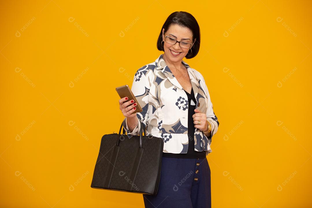 Foto de uma empresária madura atraente trabalhando com seu telefone celular