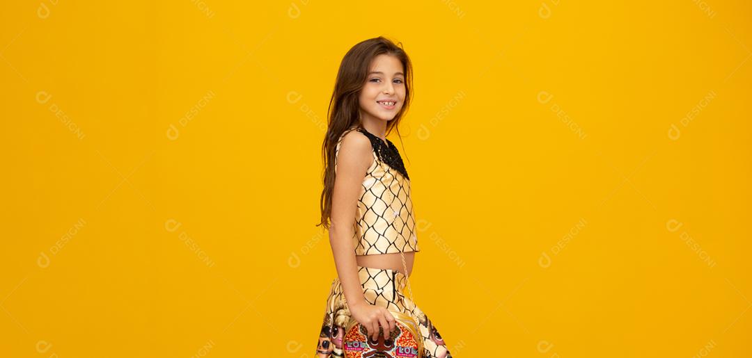 Retrato de uma menina criança sorridente feliz em fundo amarelo.